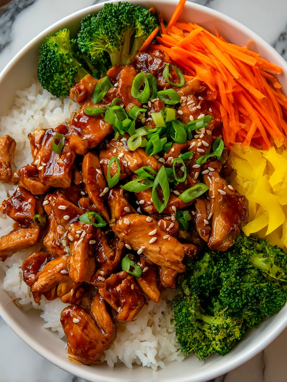 A bowl of rice with chicken and broccoli.