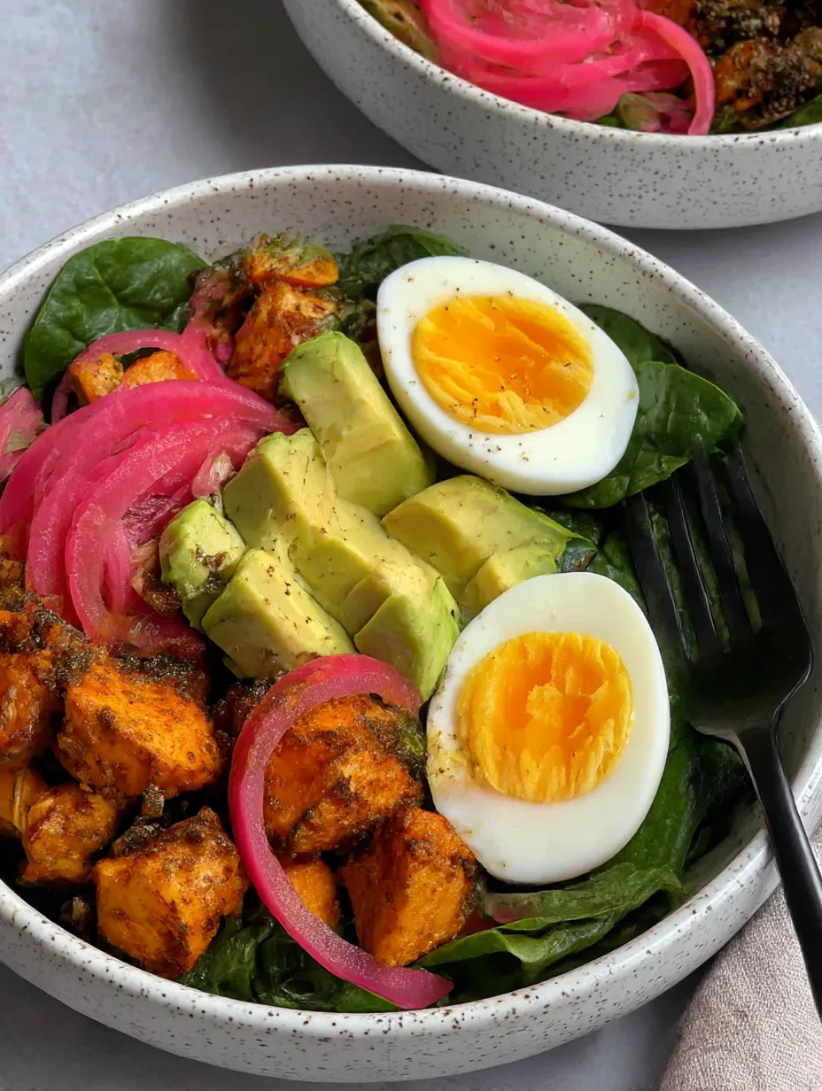 A bowl of food with eggs, sweet potatoes, and greens.