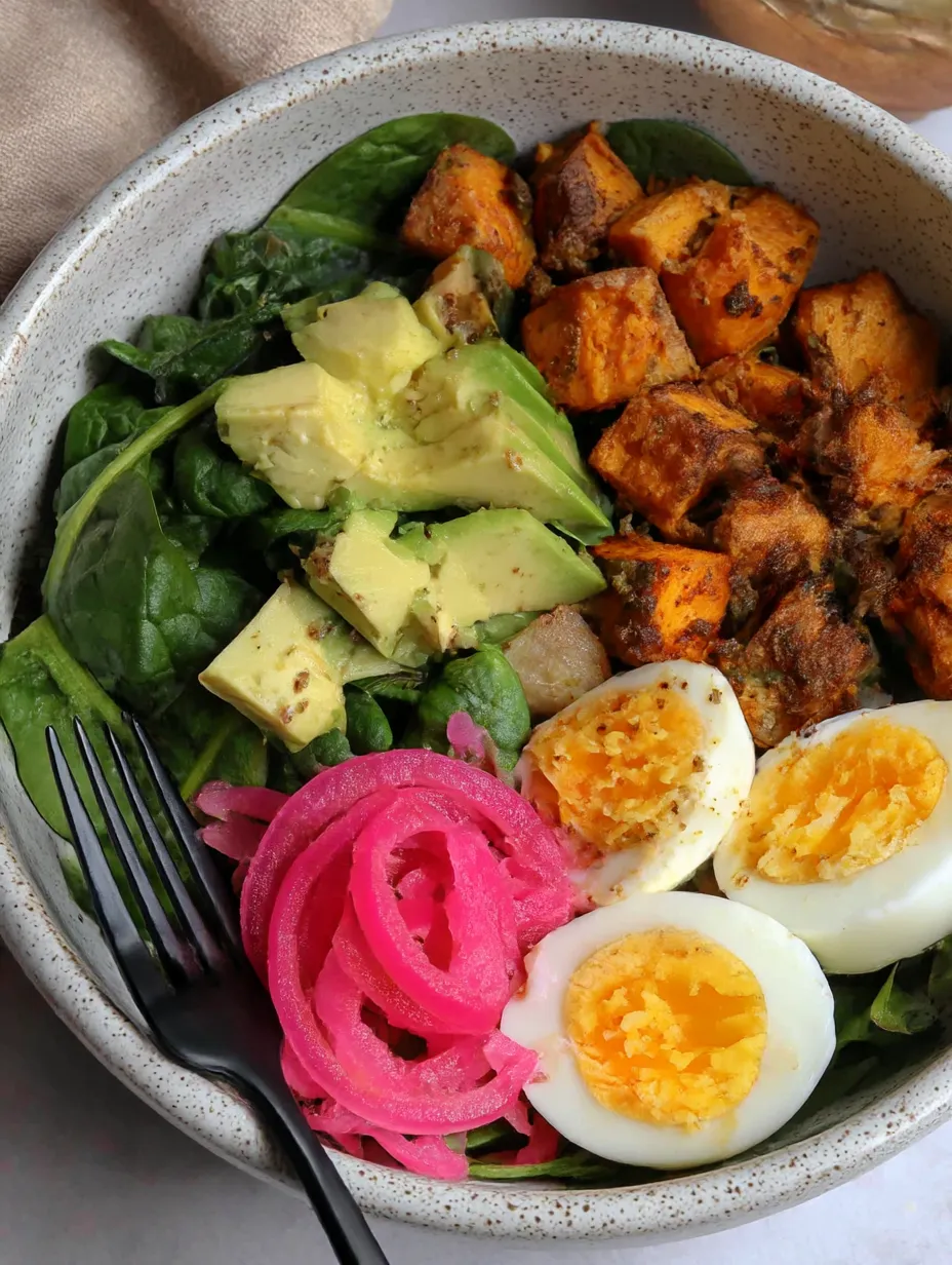 A bowl of food with eggs, sweet potatoes, and avocado.