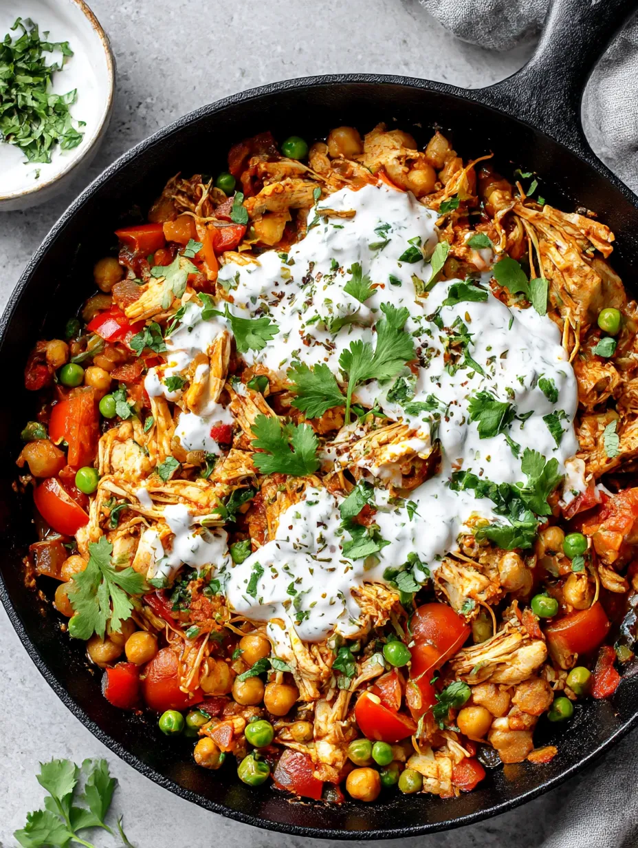 A dish of Mexican Pulled Chicken with white sauce and green onions.