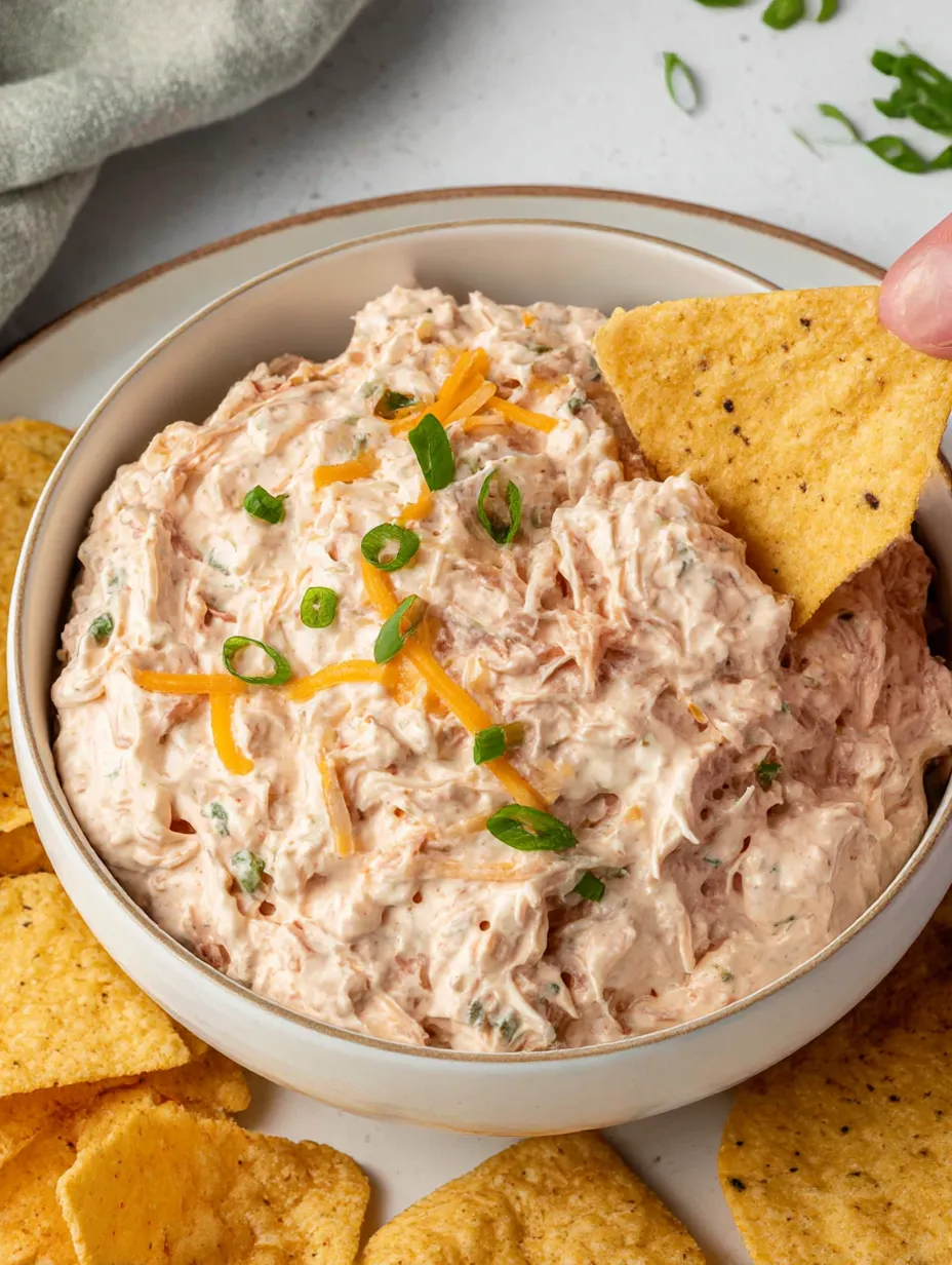 A bowl of dip with chips.