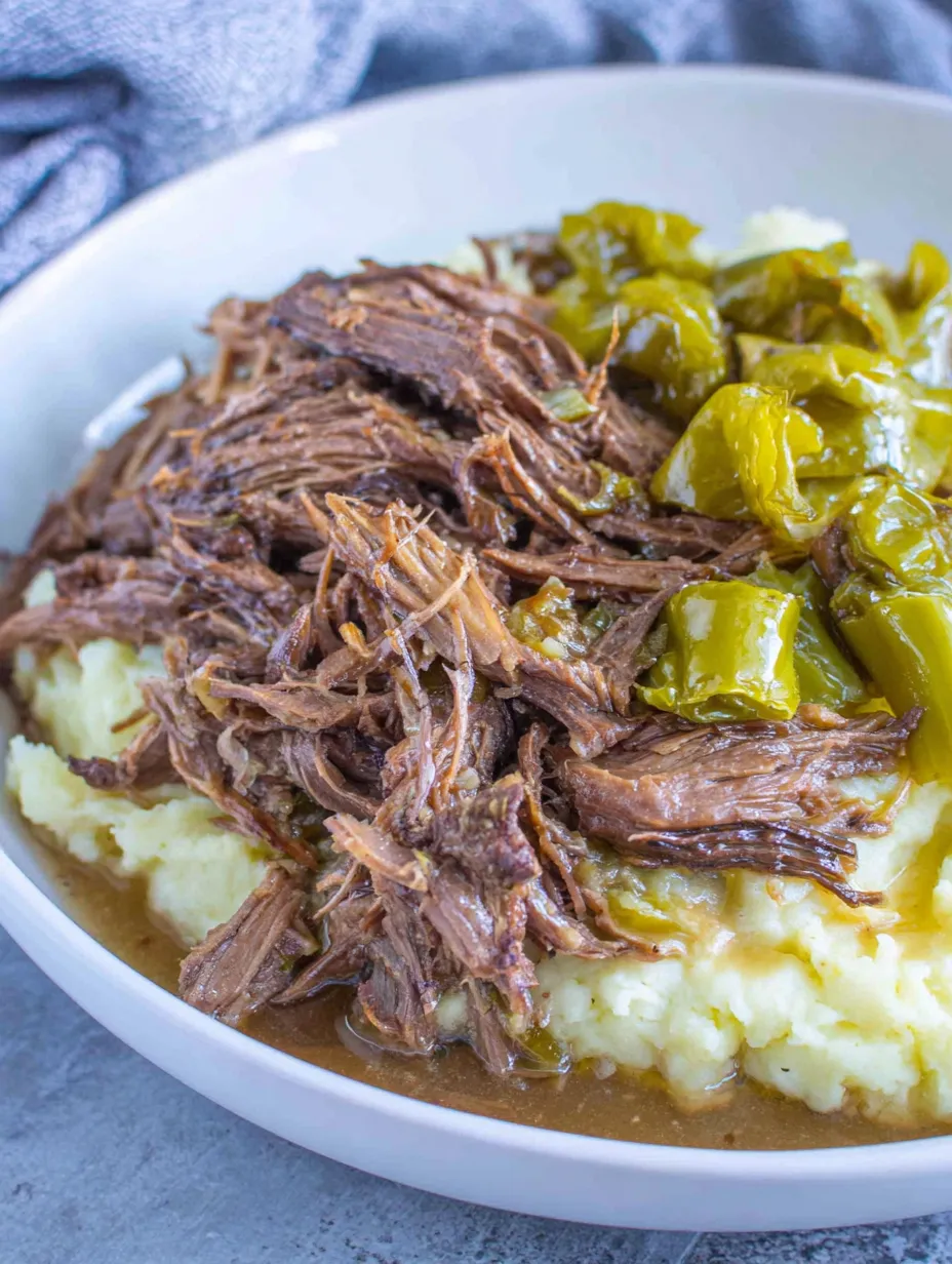 A white bowl filled with meat and potatoes.