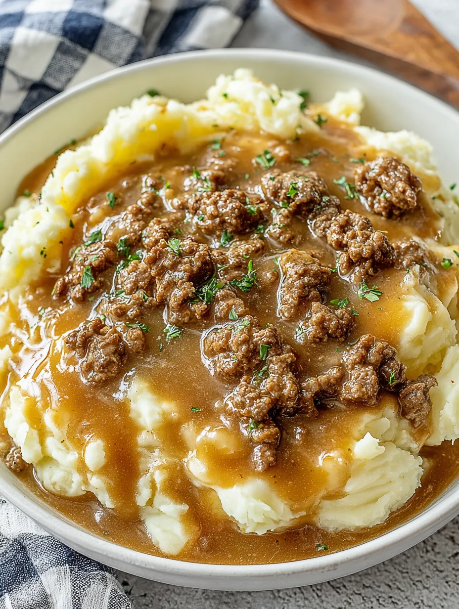 A bowl of mashed potatoes with meat on top.