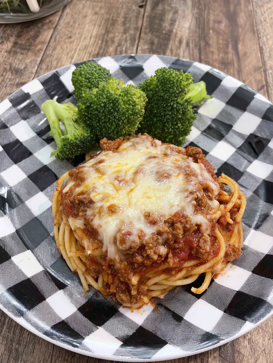 A plate of spaghetti with meat sauce and broccoli.