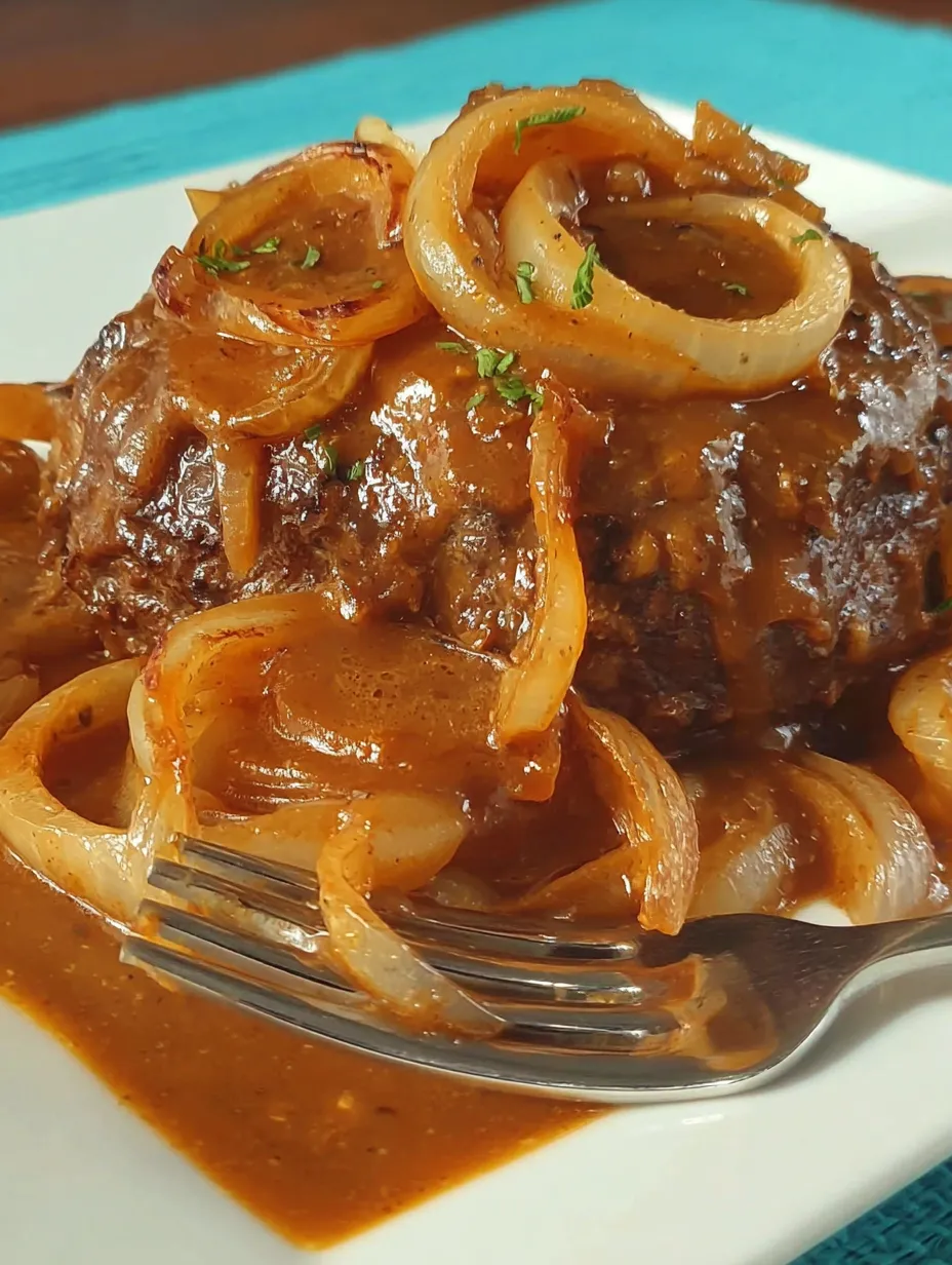 A plate of meat with onions and gravy.