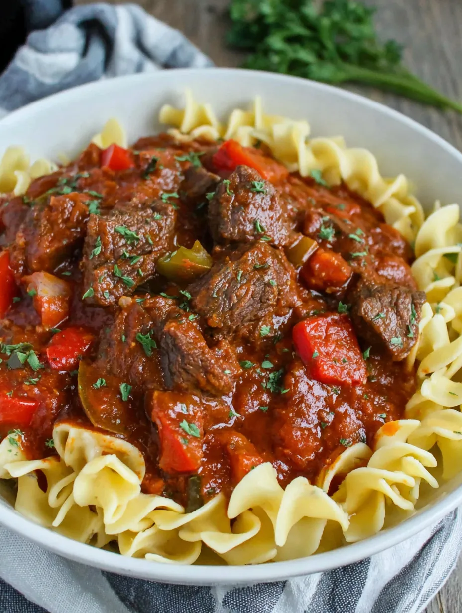 A bowl of pasta with meat and tomatoes.