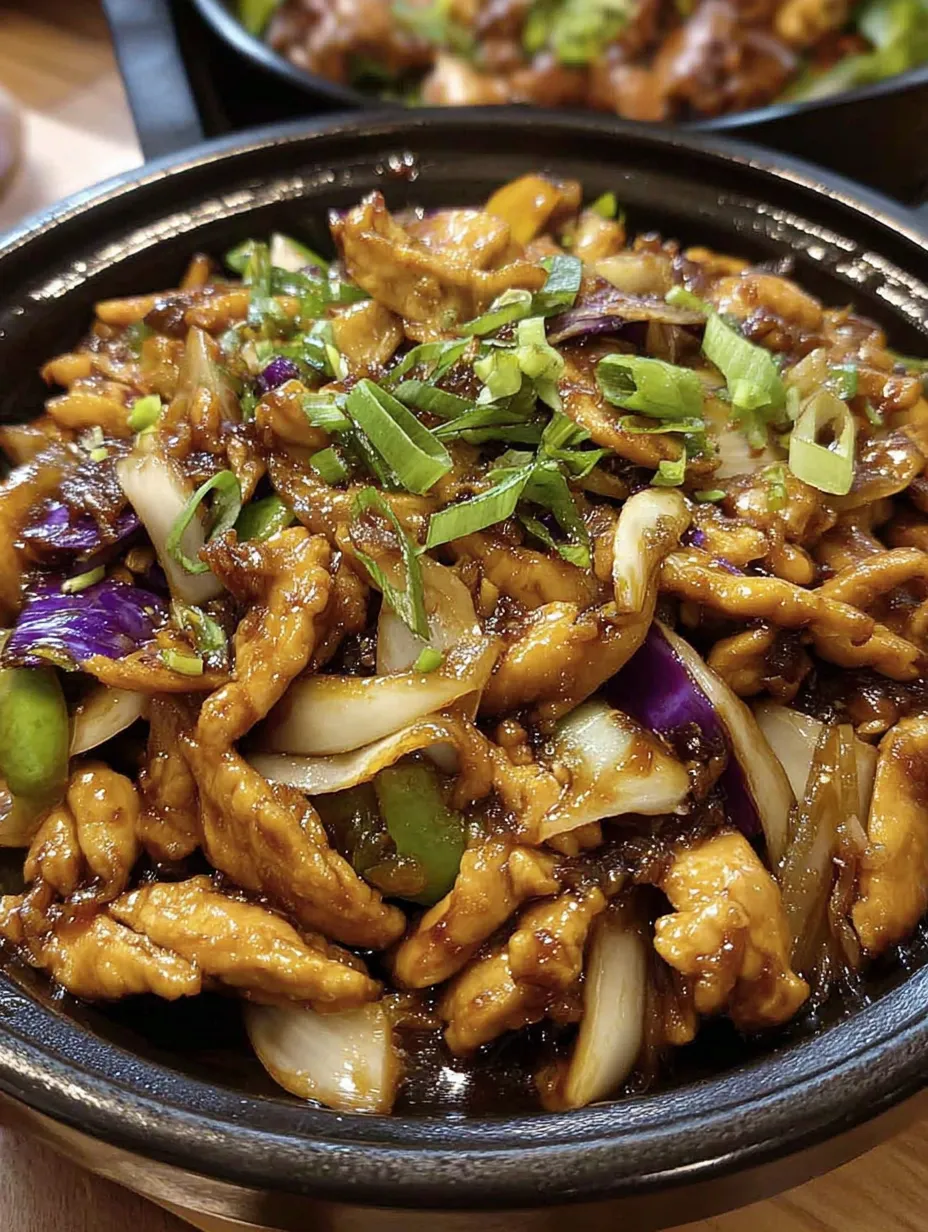 A bowl of food with onions and meat.