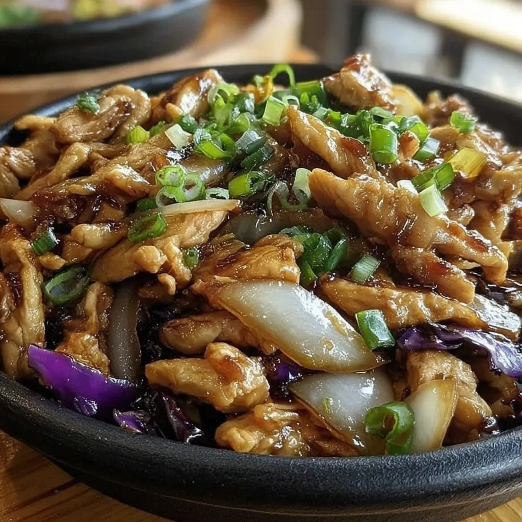 A bowl of food with meat and vegetables.