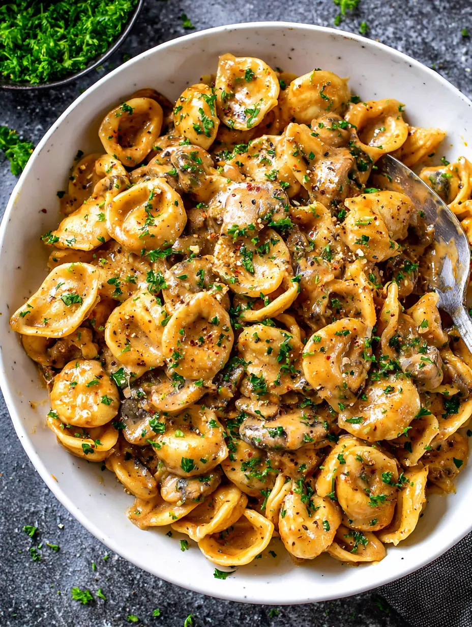 A bowl of pasta with cheese and herbs.