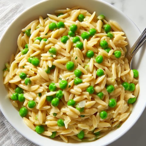 A bowl of pasta with peas and Parmesan cheese.