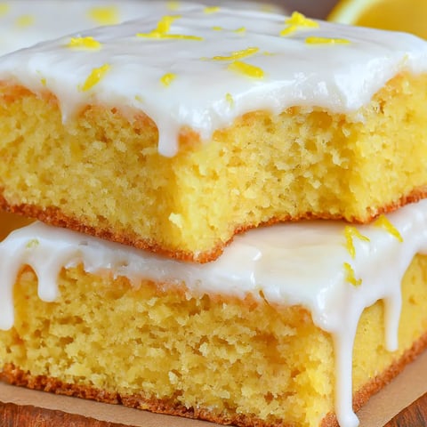 A slice of lemon cake with white icing.