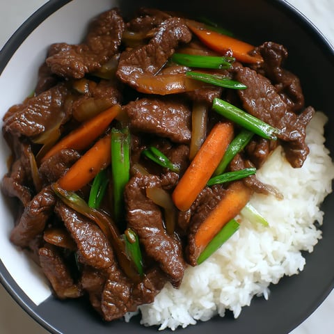 A bowl of Chinese beef and onion stir-fry.