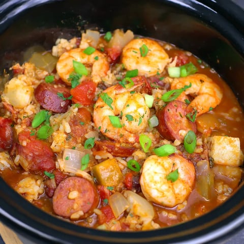 A close up of a slow cooker filled with jambalaya.