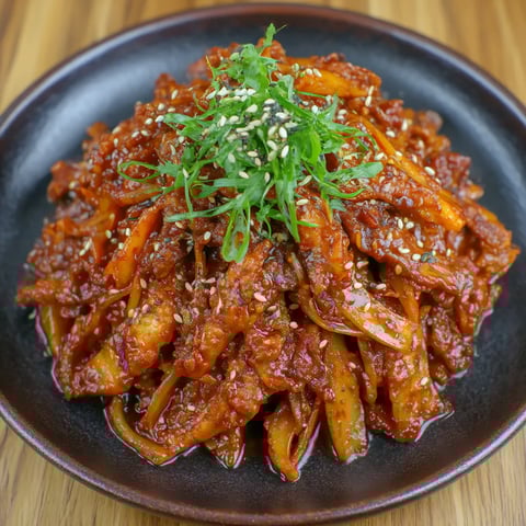 A plate of jeyuk bokkeum with sesame seeds on top.