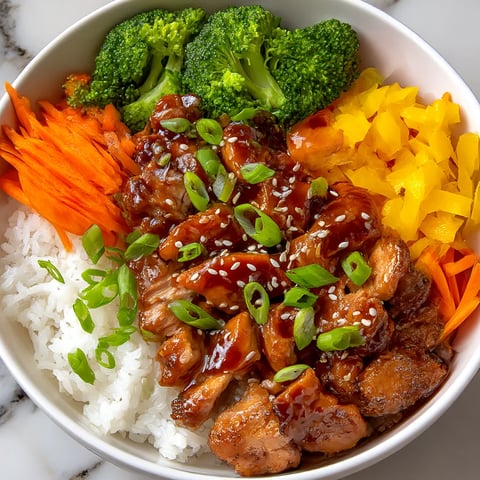 A bowl of food with rice, chicken, and broccoli.