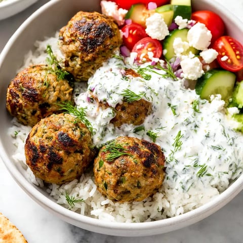 A bowl of Greek turkey meatballs with rice and vegetables.