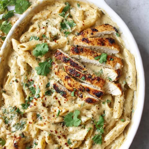 A bowl of pasta with chicken and vegetables.