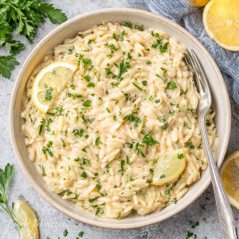 A bowl of pasta with lemon and herbs.