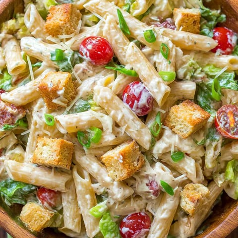 A bowl of chicken caesar pasta salad.