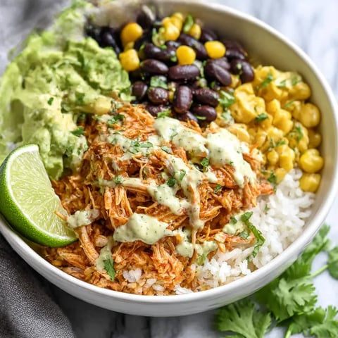A bowl of food with rice, beans, corn, and chicken.