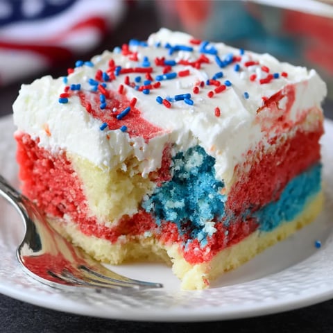 A slice of a patriotic poke cake.