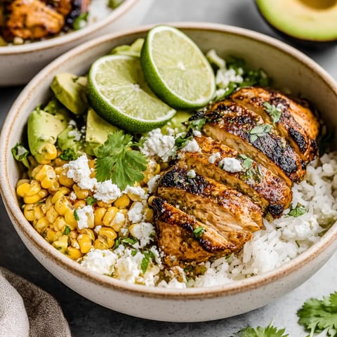 A bowl of rice with chicken and lime.