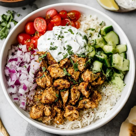 A bowl of chicken gyro with rice and vegetables.