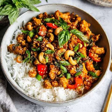 A bowl of rice with chicken and vegetables.