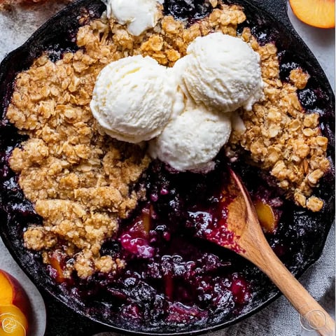 A close up of a blueberry peach crumble.