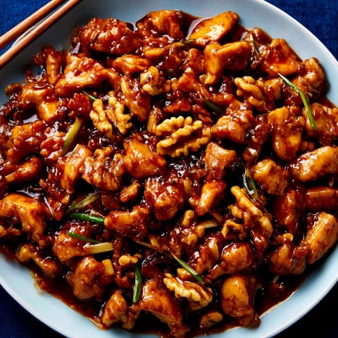 A plate of stir fry chicken with yellow bean paste.