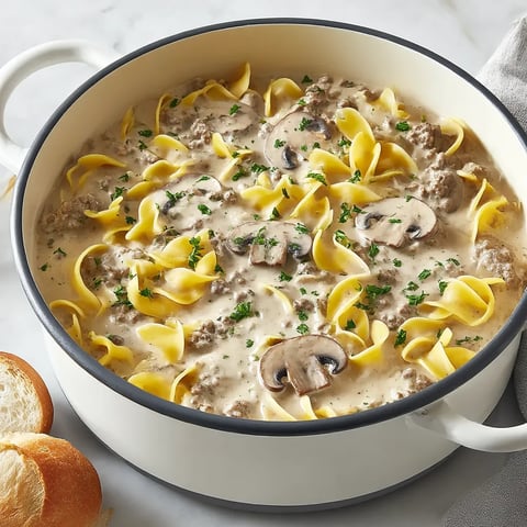 A bowl of beef stroganoff with noodles and mushrooms.