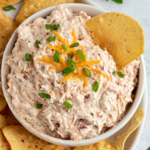 A bowl of dip with chips.