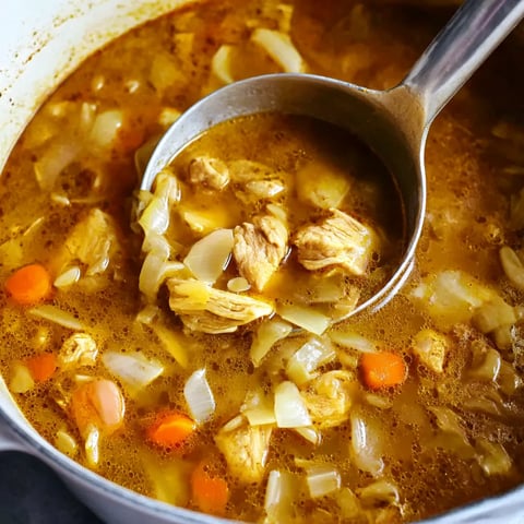 A spoon in a bowl of soup.