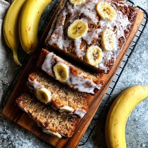 A slice of banana bread with bananas on top.