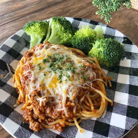 A plate of spaghetti with meat sauce and broccoli.