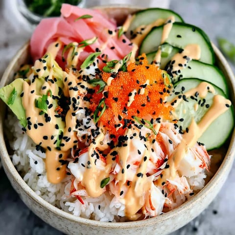 A bowl of food with rice, cucumbers, and seafood.