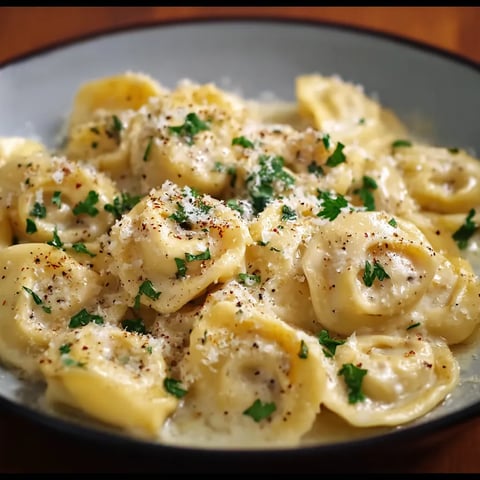 A plate of pasta with cheese and herbs.