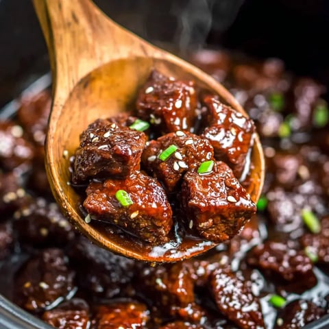 A wooden spoon with meat on it.