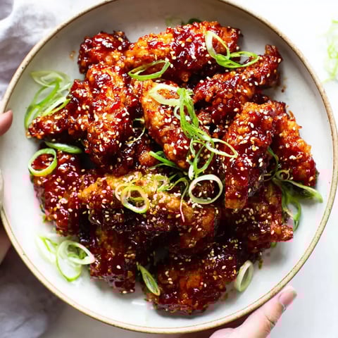 A plate of chicken with green onions.