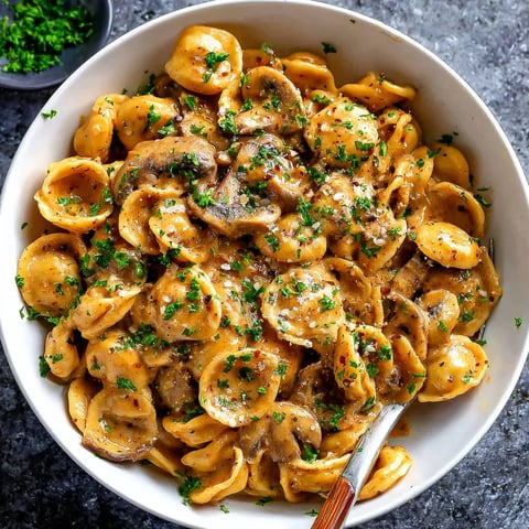 A bowl of pasta with mushrooms and cheese.