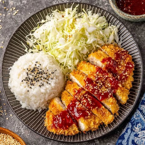 A plate of food with rice, cabbage, and meat.