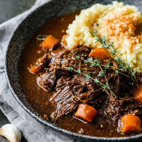 A bowl of food with meat and rice.